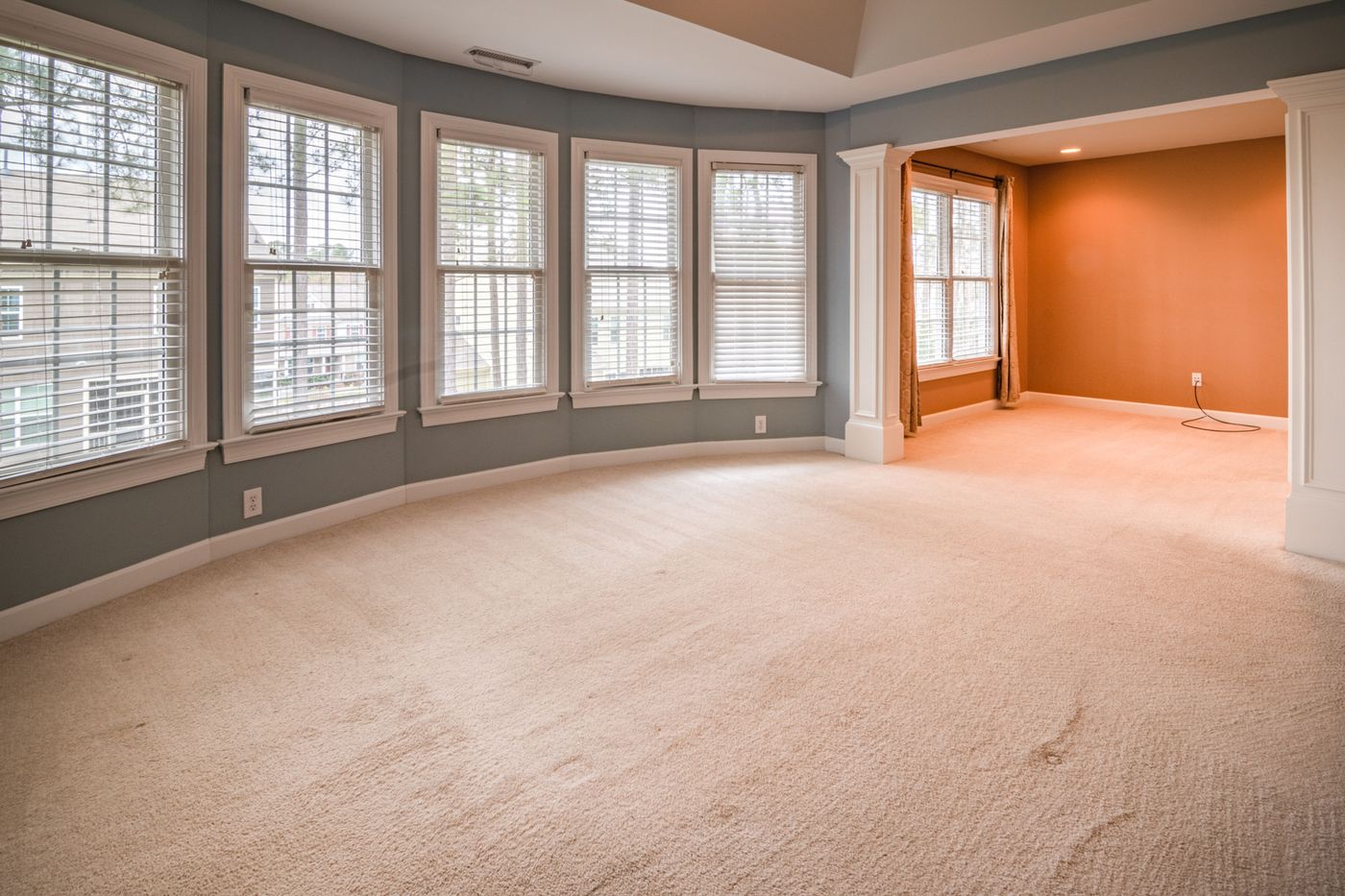 A bright, empty room with freshly cleaned carpet ready for inspection